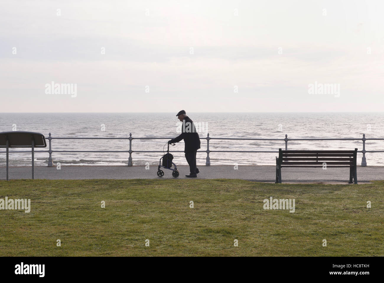 Senior citizen, pensioner walking with aid of zimmer frame, seafront Bexhill-on-sea Stock Photo