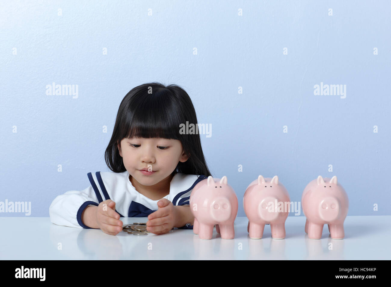 Portrait of girl with three piggy banks Stock Photo - Alamy