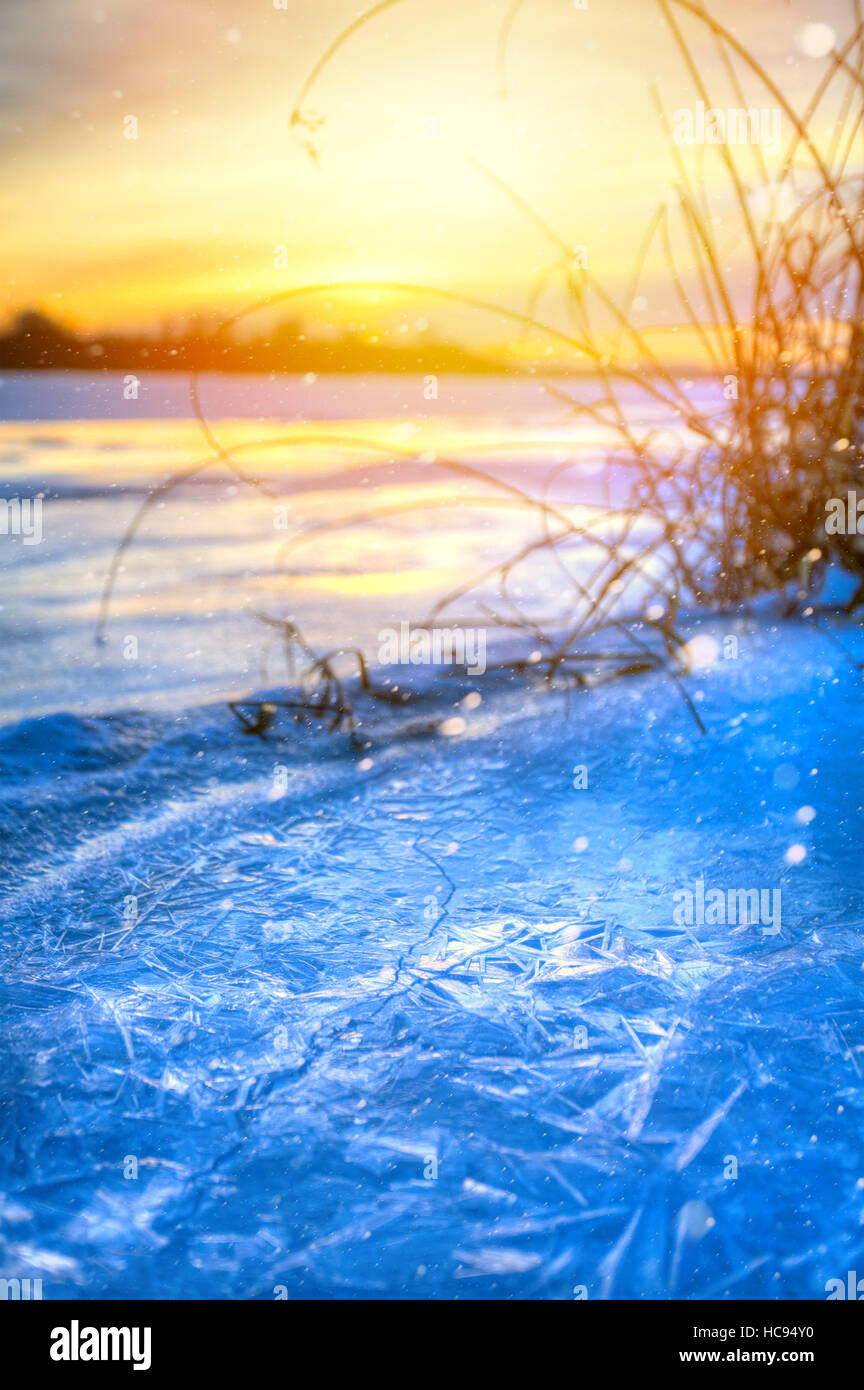 winter landscape panorama; sunset on the bank of a frozen river; ice and snow Stock Photo