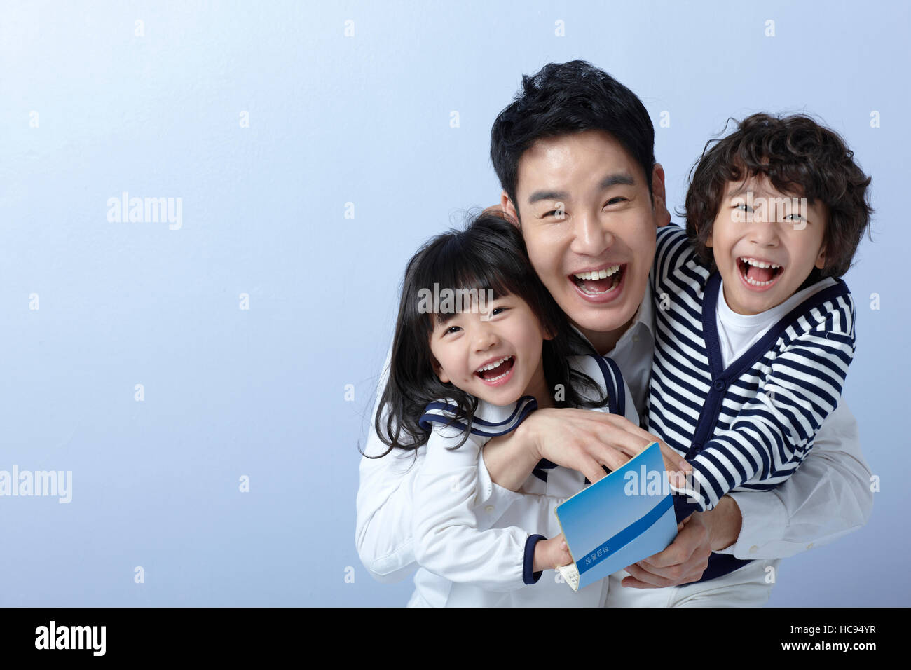 Portrait of smiling father, daughter and son with bankbook Stock Photo