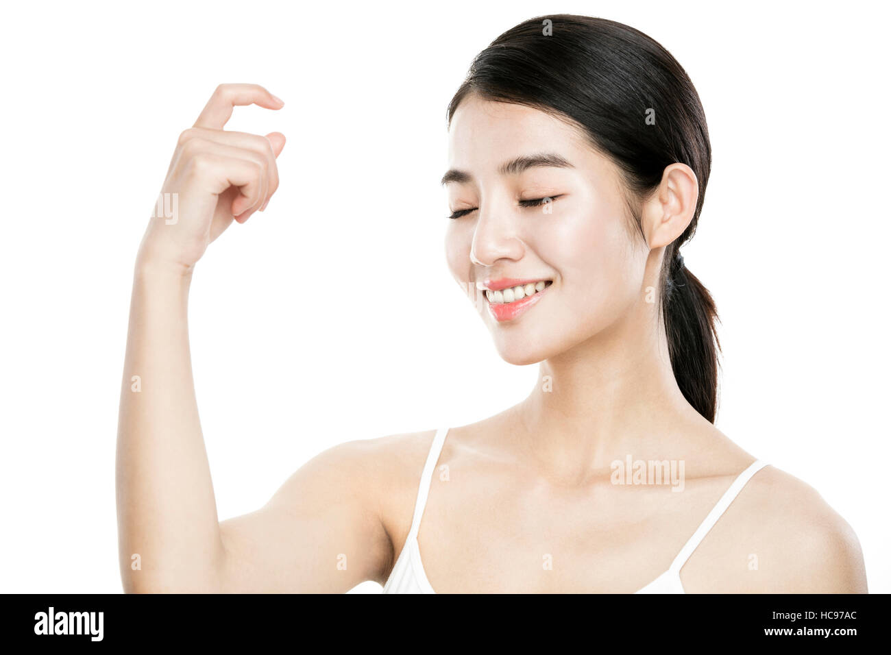 Portrait of young smiling woman spraying mist closing eyes Stock Photo