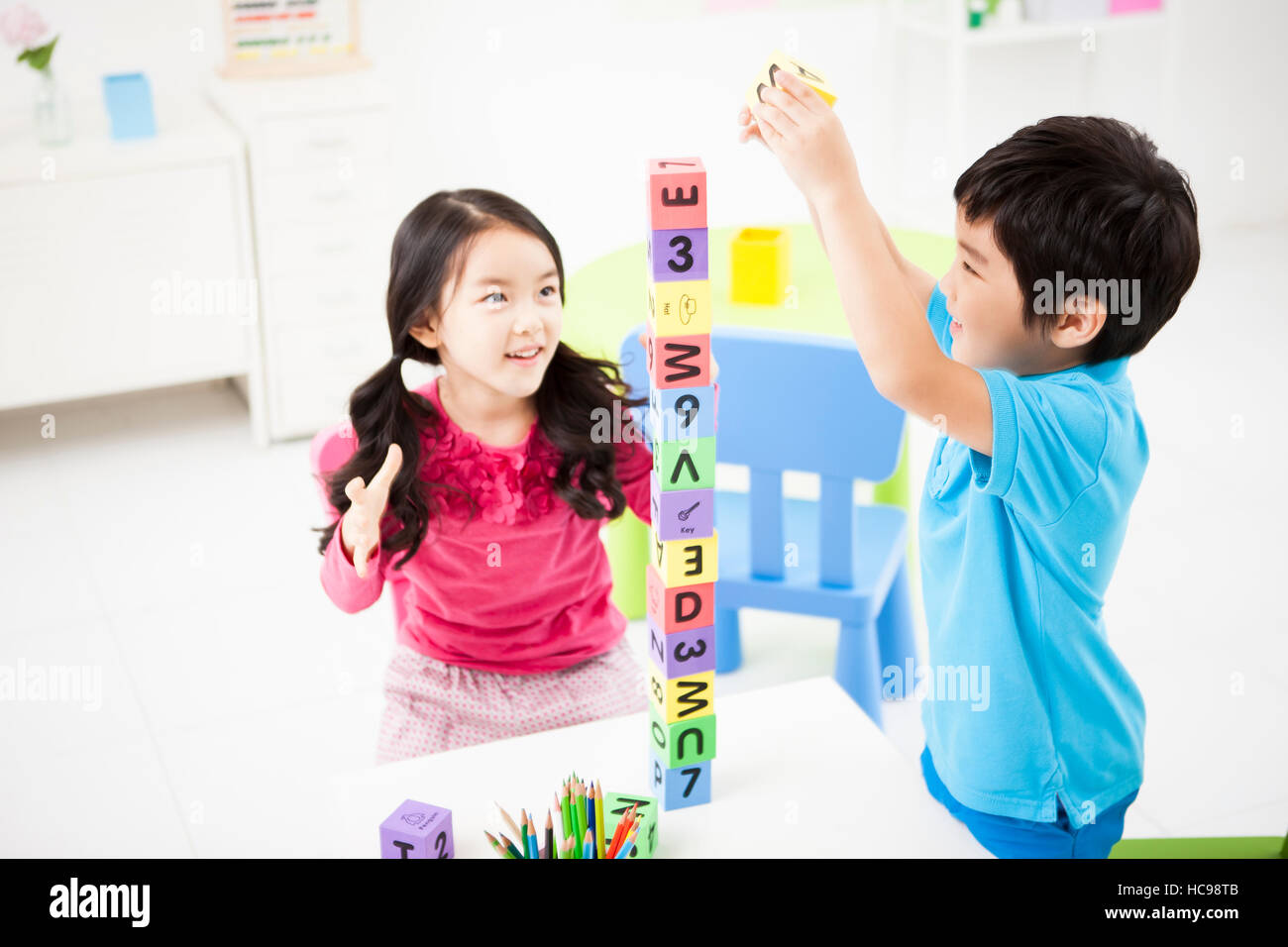 Two smiling children playing with blocks Stock Photo
