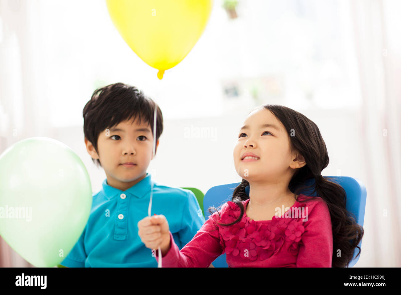 Portrait of smiling boy and girl with a balloon Stock Photo