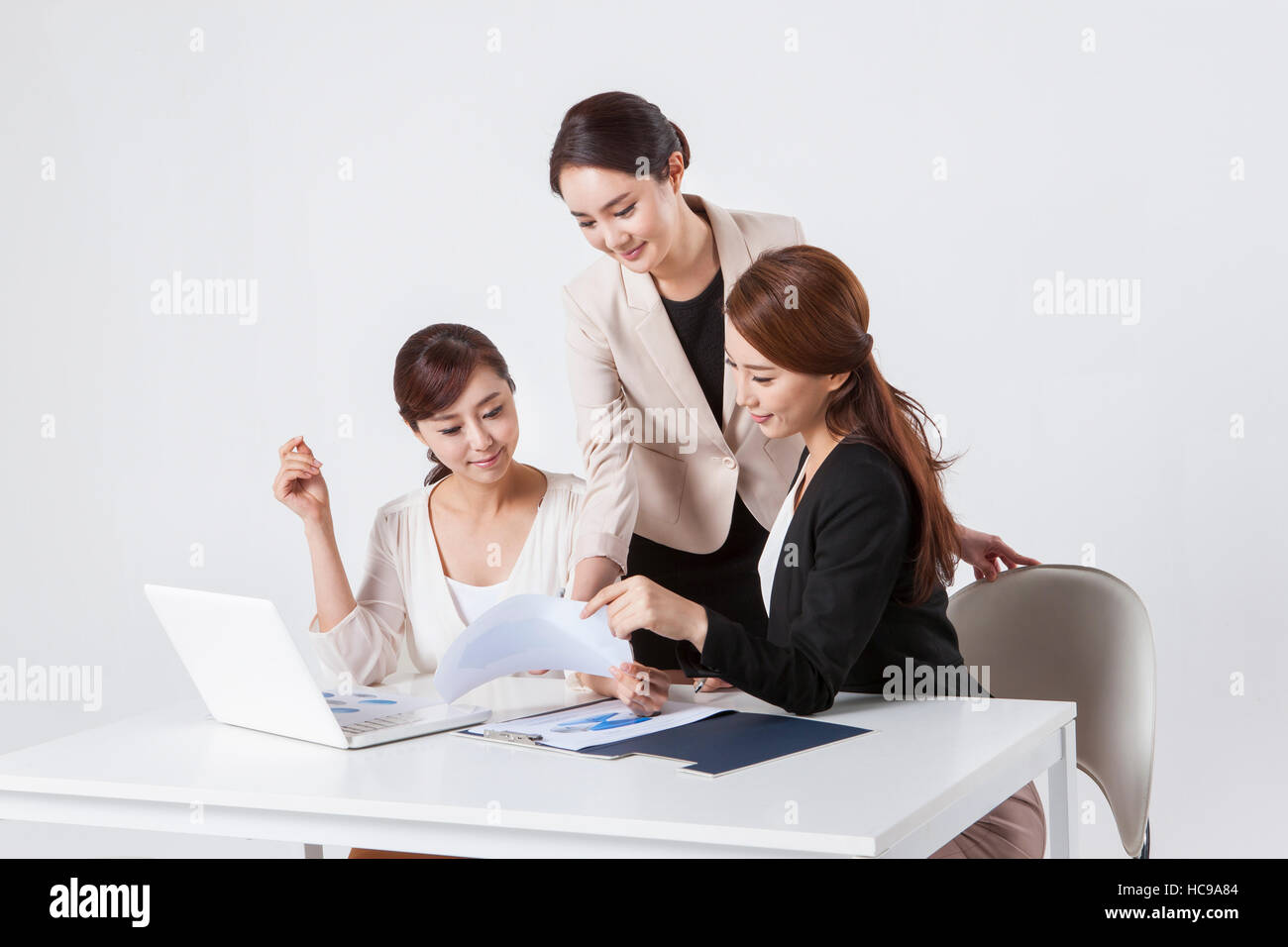 Three young smiling businesswomen having a meeting Stock Photo - Alamy