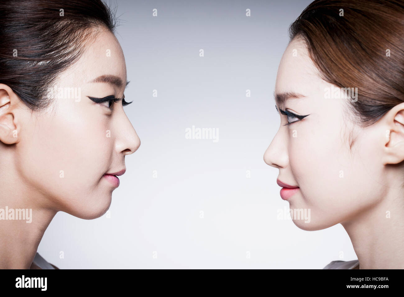 Side view of faces of two young Korean women Stock Photo