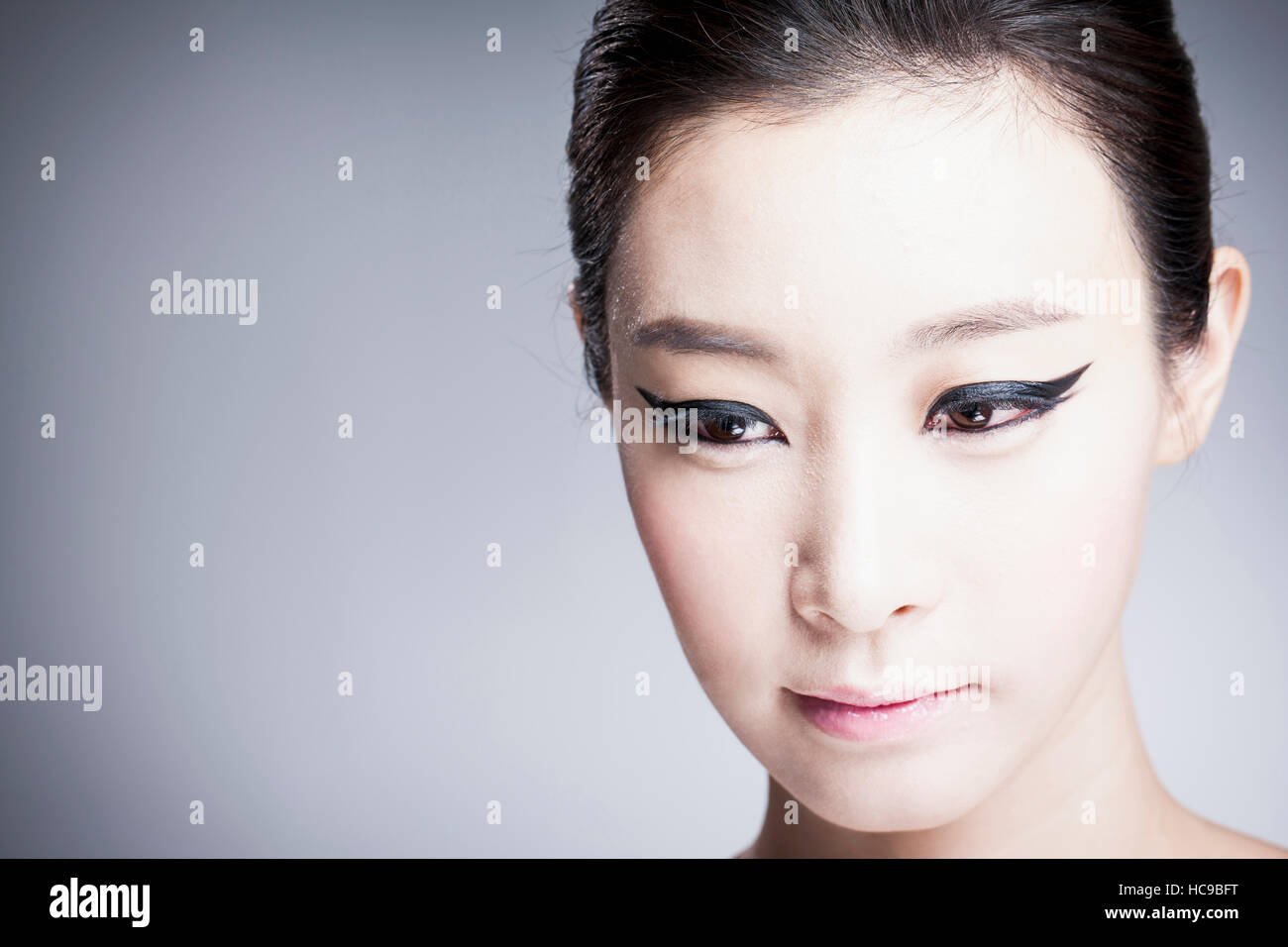 Face of young beautiful Korean woman in black eyeliner Stock Photo