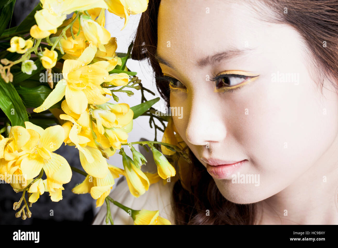 Portrait of young woman with yellow flowers Stock Photo - Alamy