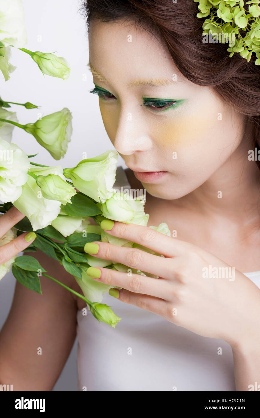 Portrait of young smiling Korean woman smelling flowers Stock Photo - Alamy