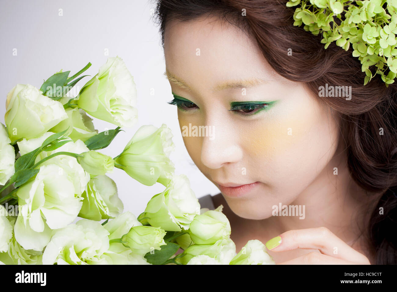 Portrait of young Korean woman smelling flowers Stock Photo