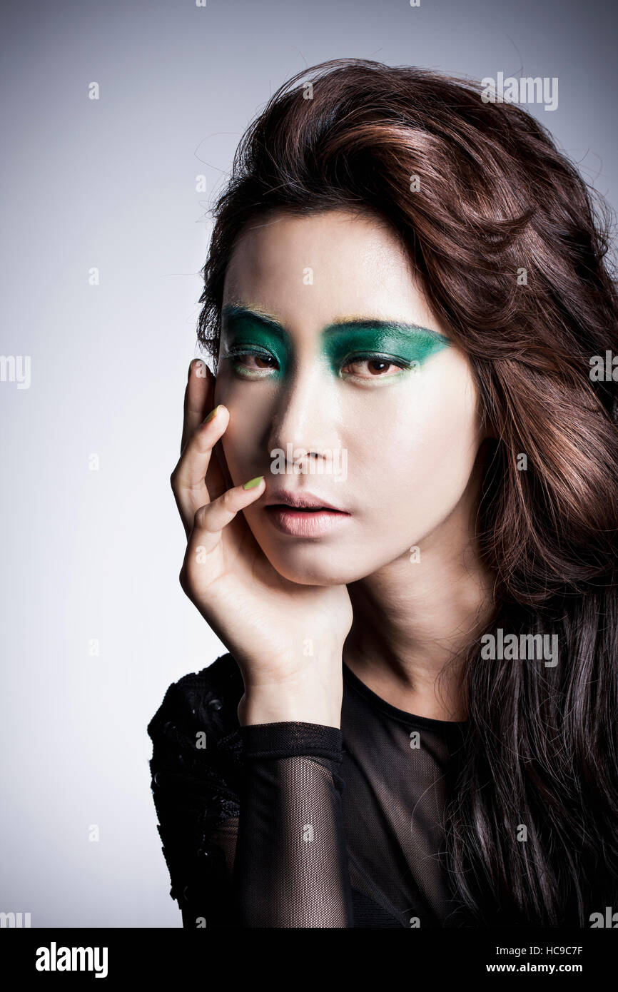 Portrait of young Korean woman in black clothes and green eye shadow posing Stock Photo