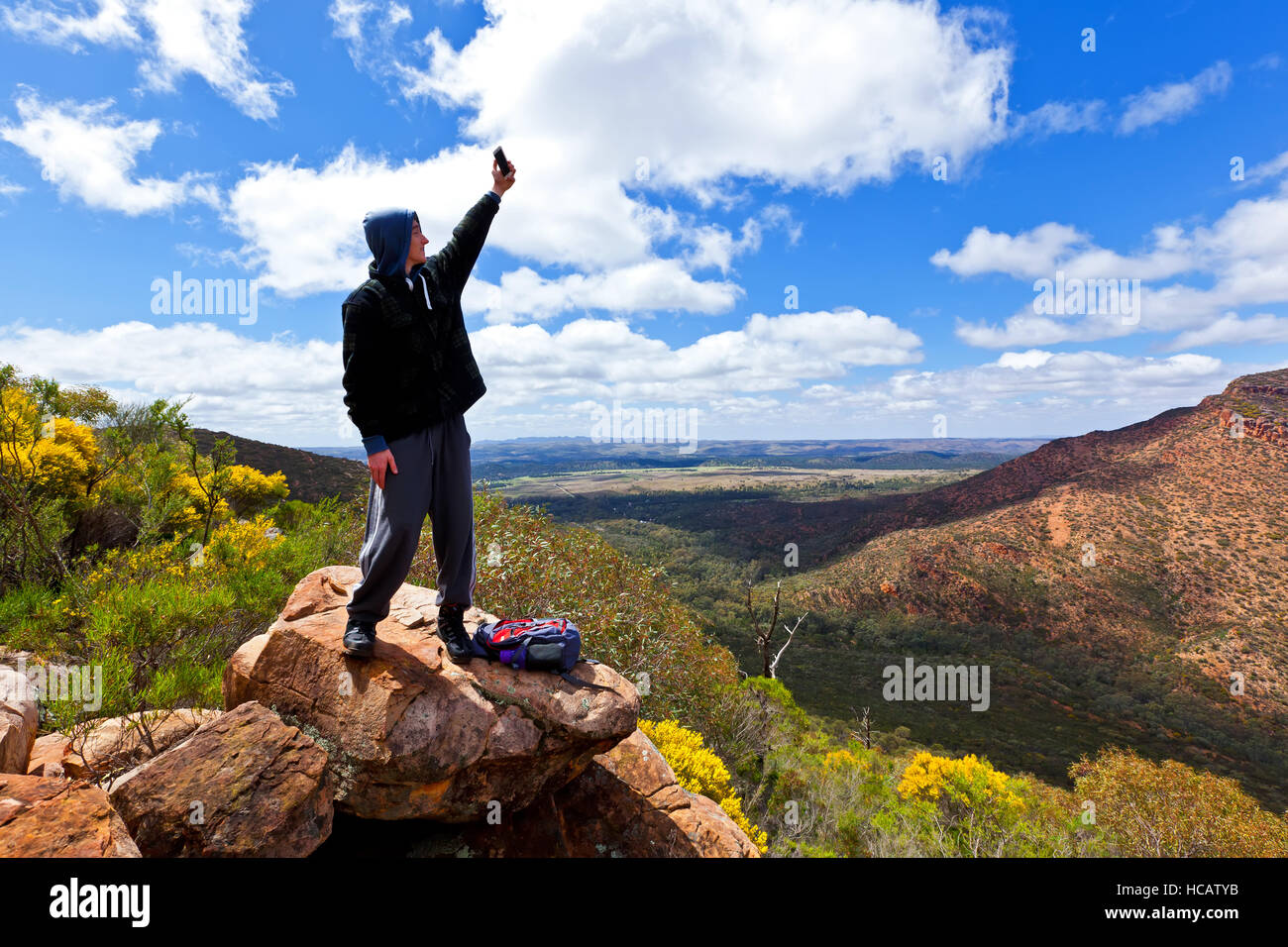 Young man teenager holding mobile phone taking a outback landscape landscapes Flinders Ranges South Australia Australian Stock Photo - Alamy