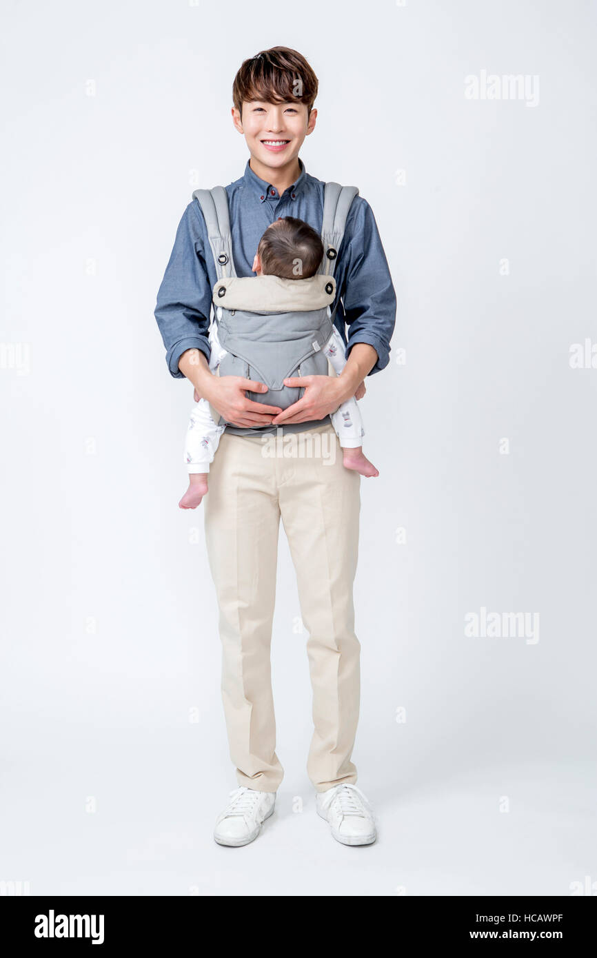 Loving father holding his baby in a carrier standing Stock Photo Alamy