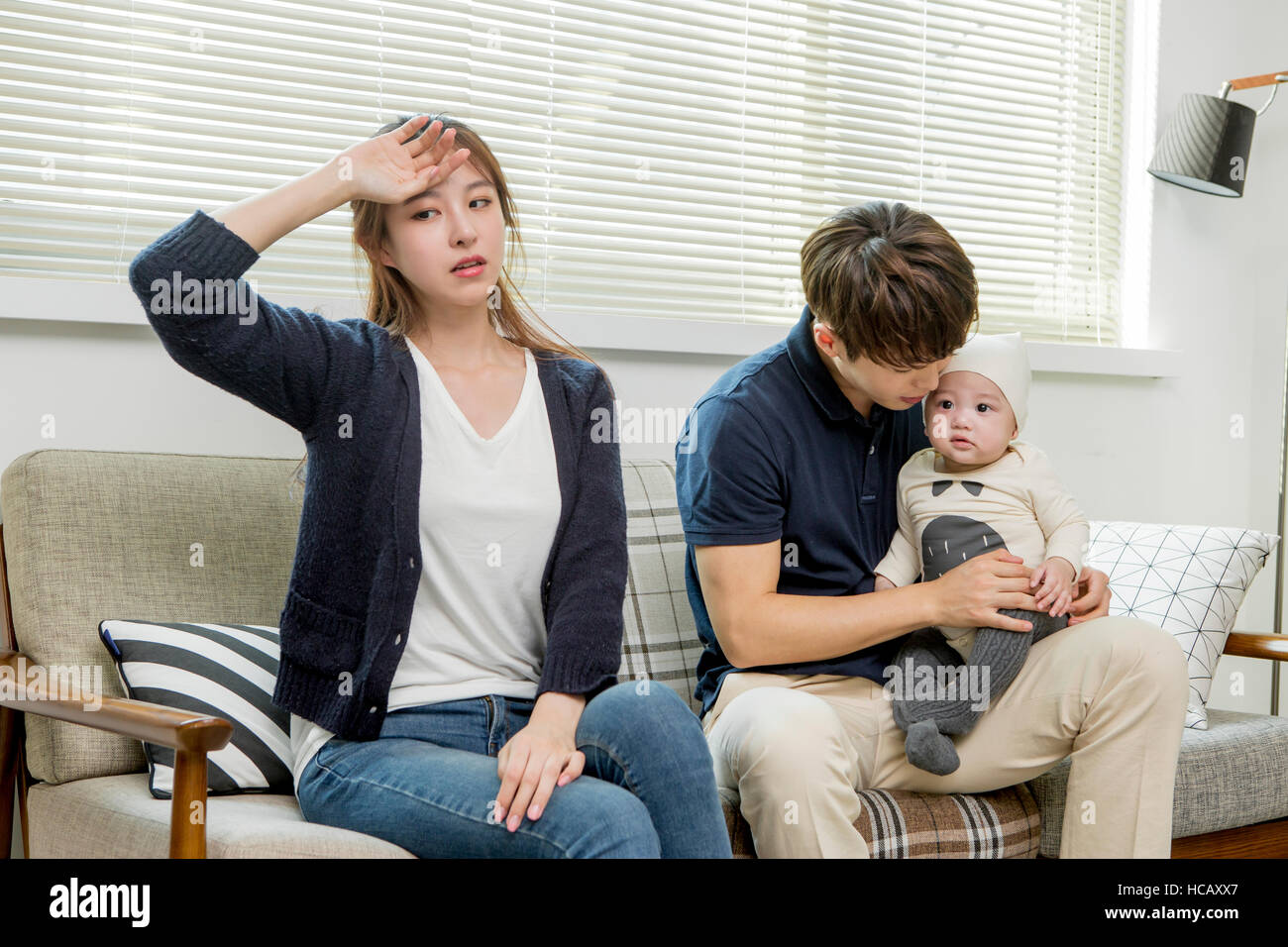 Stressful mother and father with their baby Stock Photo - Alamy