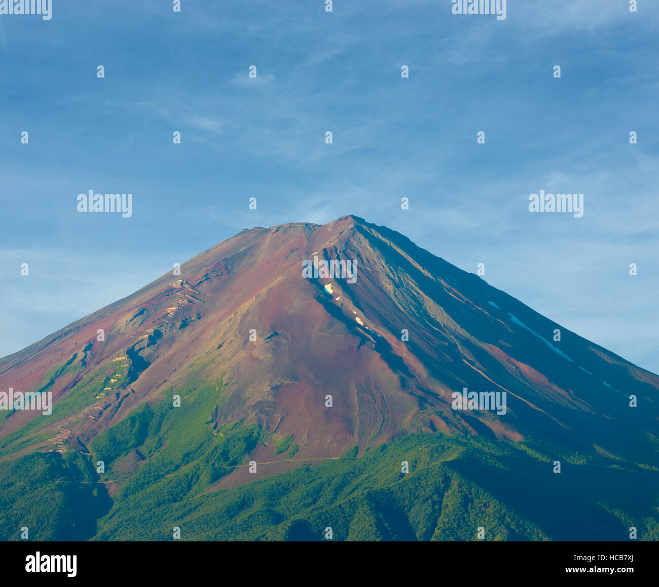 Detailed distant telephoto view of brown dirt volcanic cone and hiking trail on early summer morning from Kawaguchiko Lake in 5 Stock Photo
