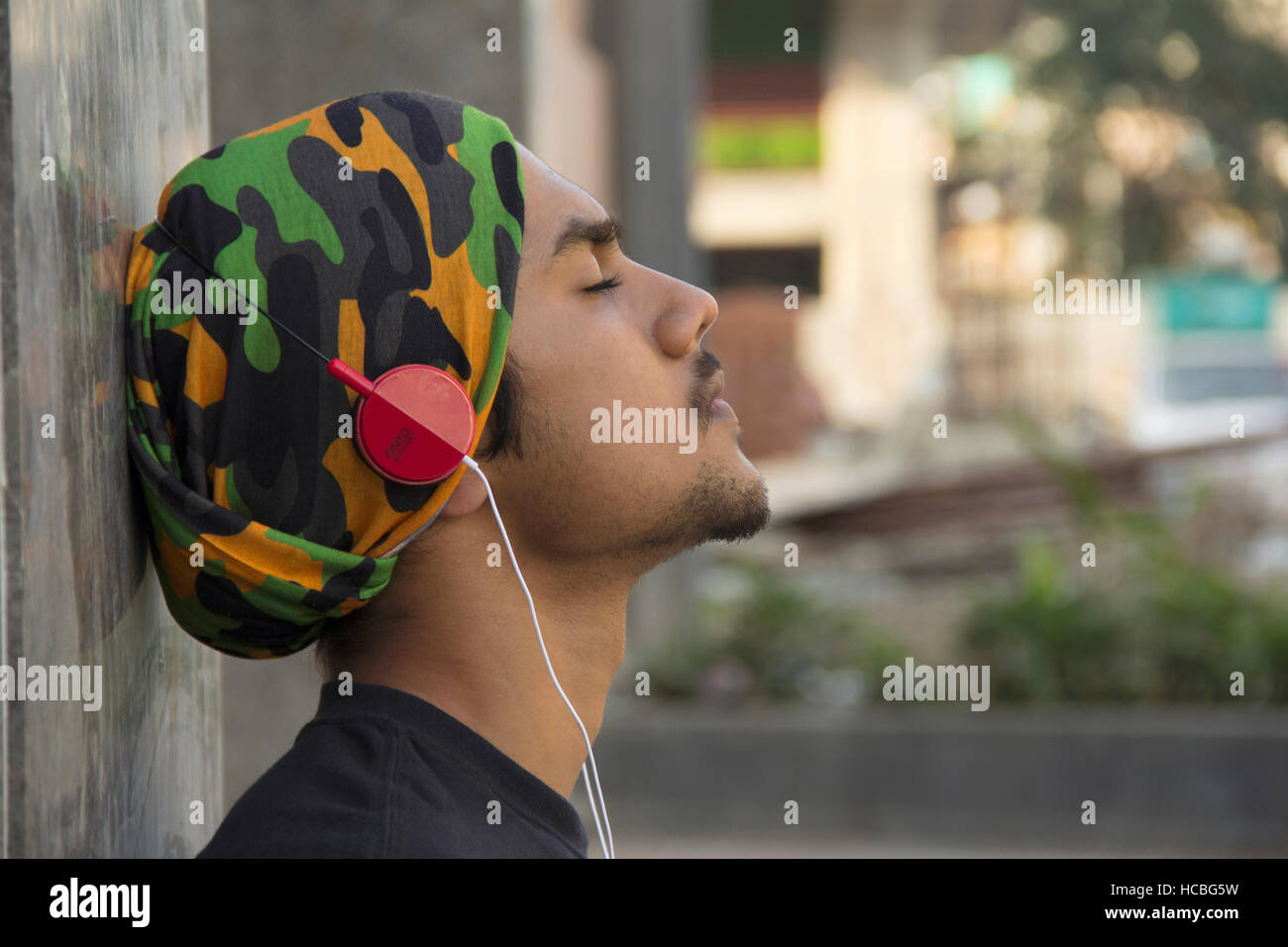 Close-up of a young Indian boy enjoying music with headphone Stock Photo