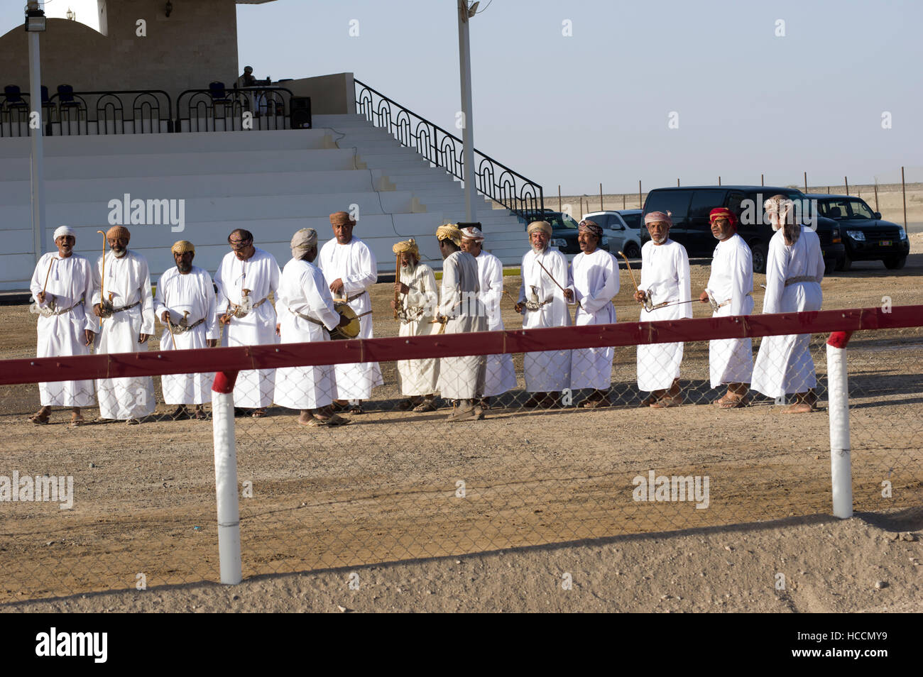 Musicians playing and singing traditional Omani music with instruments at a camel race in the