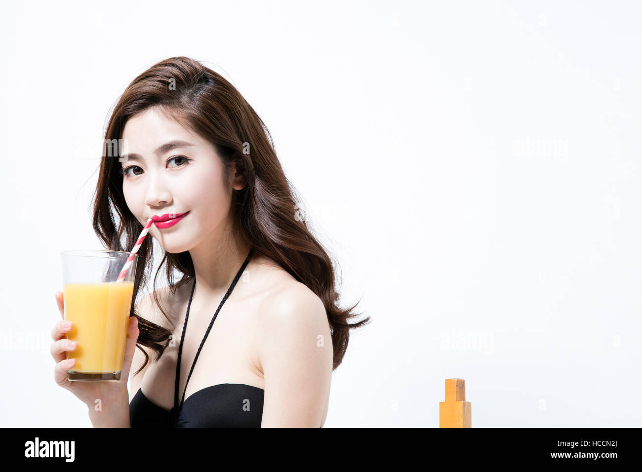 Portrait of young woman in bikini drinking juice Stock Photo