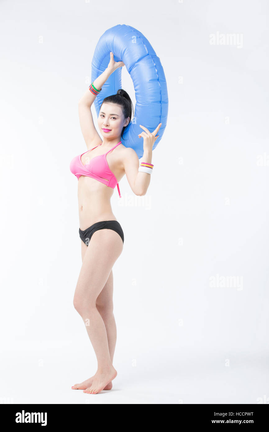 Young slim woman in bikini posing with a tube Stock Photo