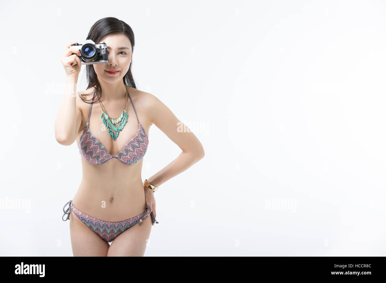Young slim woman in bikini posing with camera Stock Photo