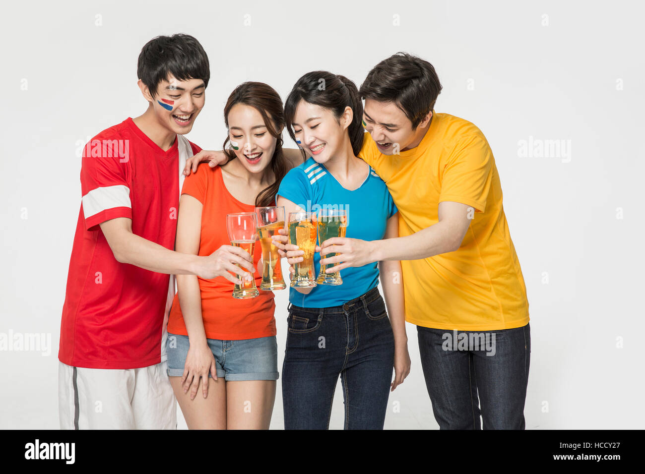 Young smiling people with beer glasses cheering Stock Photo