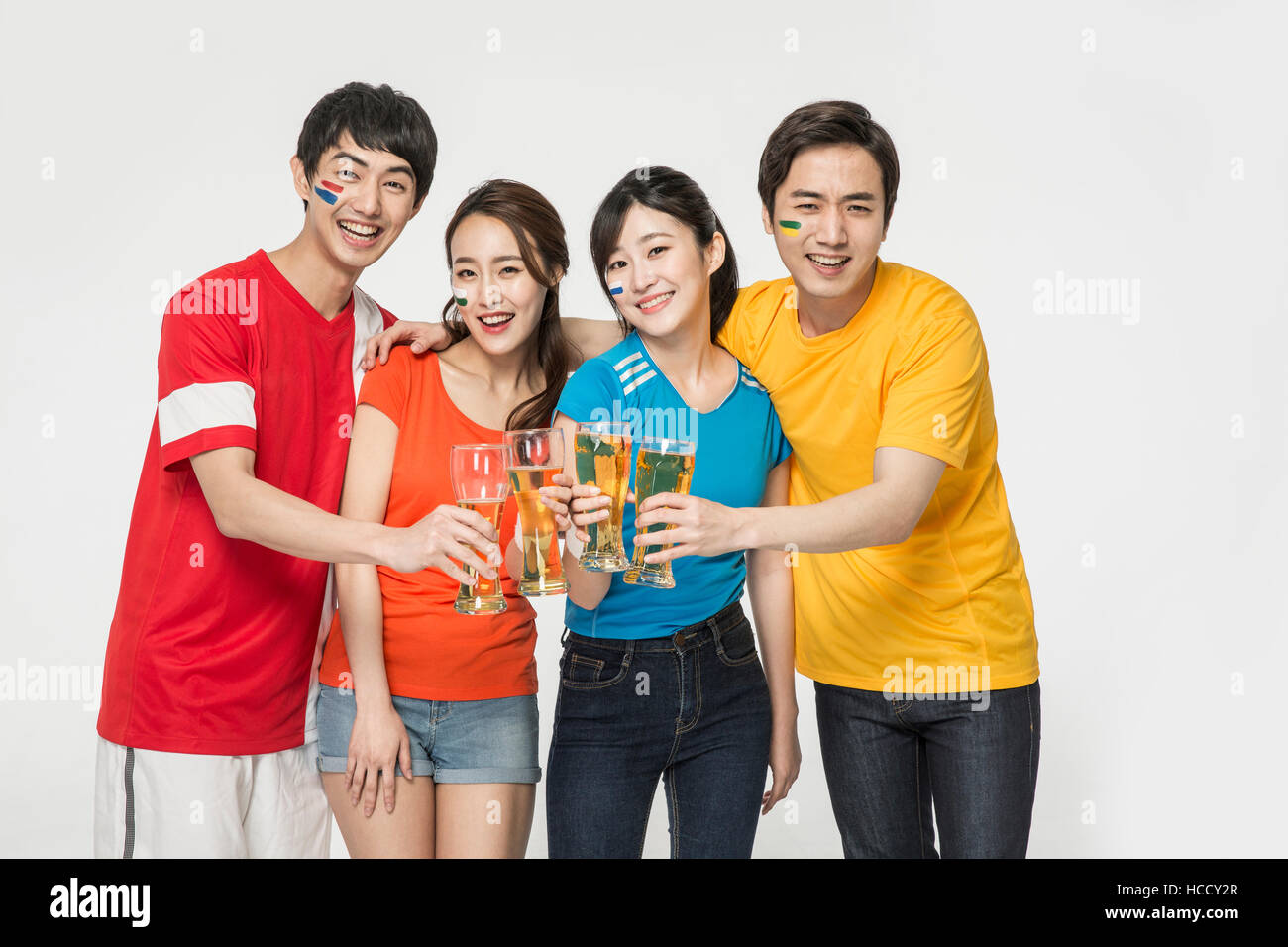 Young smiling people with beer glasses cheering Stock Photo