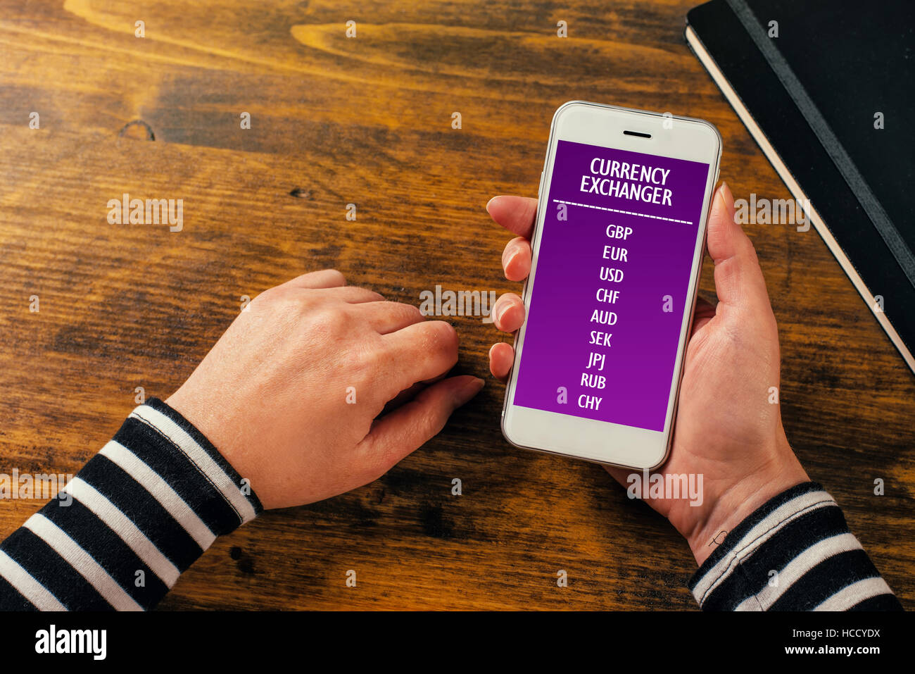 Mobile phone currency exchange application concept, female hands using