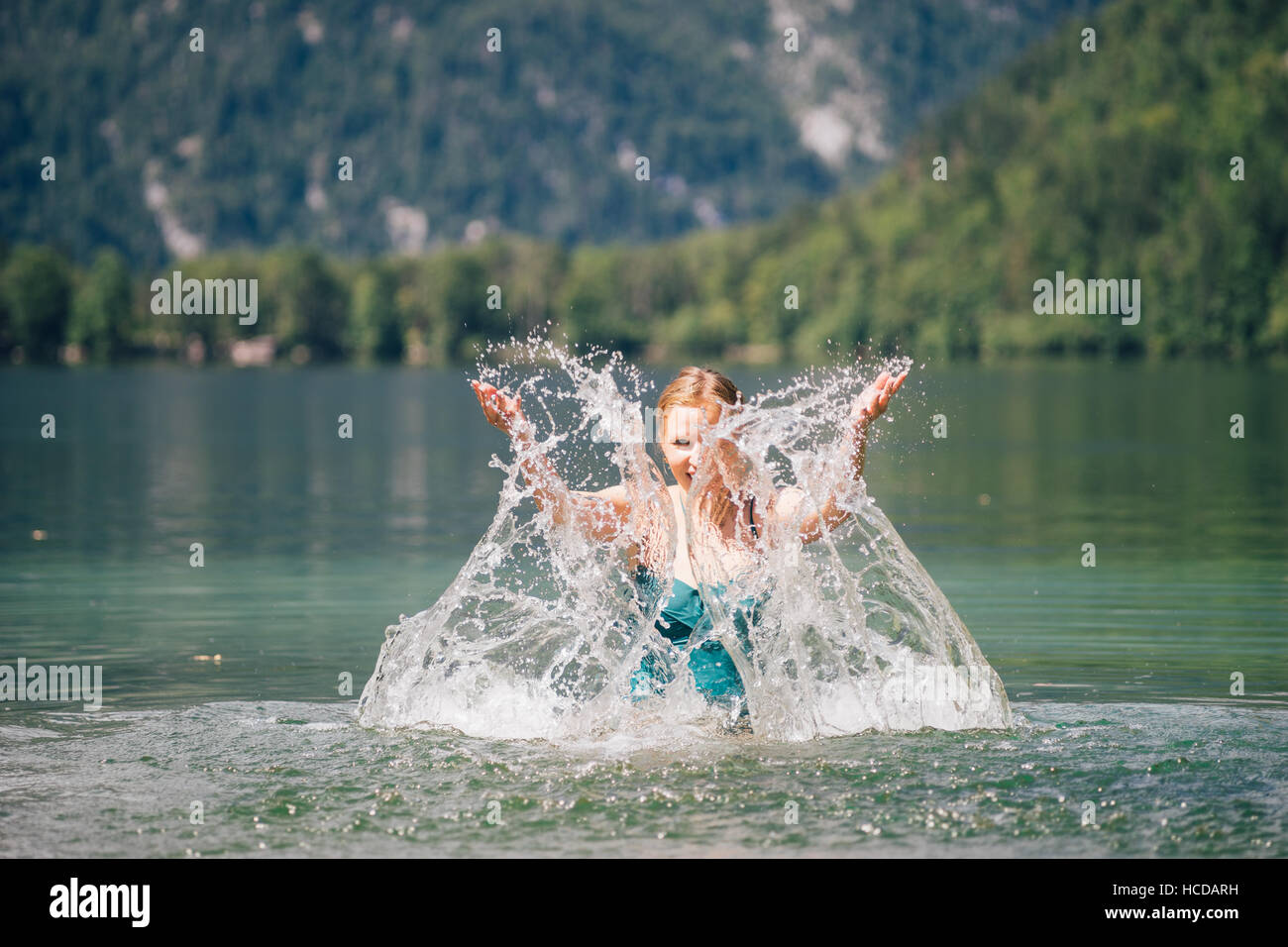 Young beautiful woman splashing in lake and looking through water. Recreation and healthy lifestyle concept Stock Photo