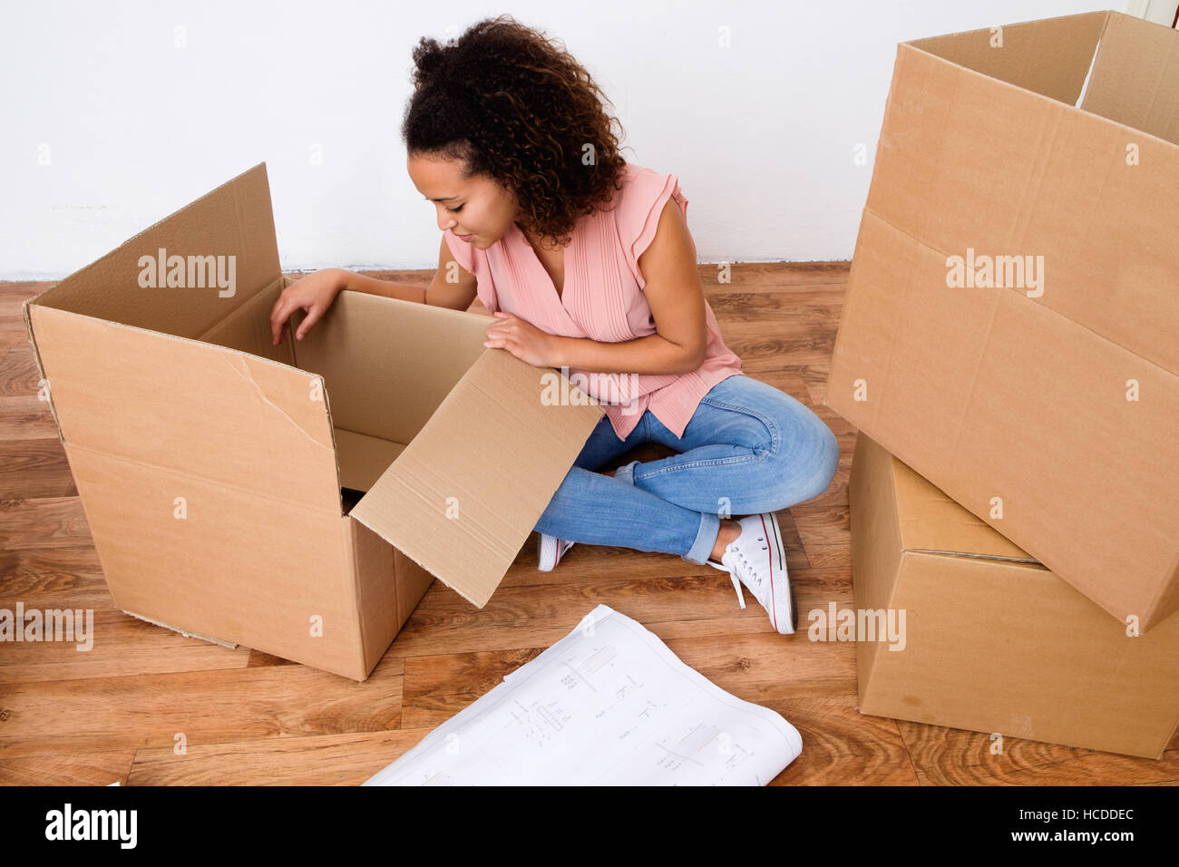 Desperate and tired woman during home relocation Stock Photo