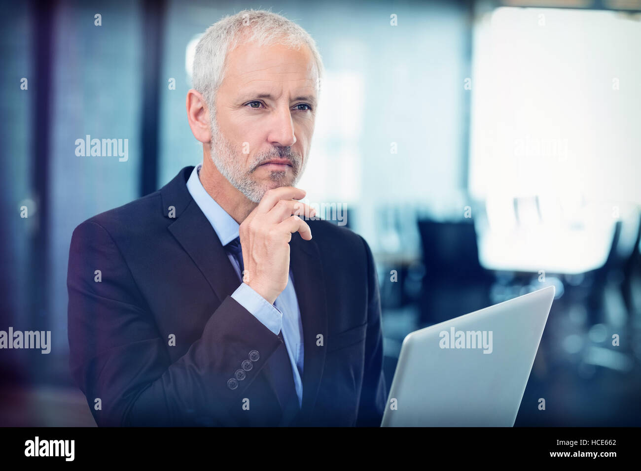 Thoughtful businessman thinking while working on laptop Stock Photo - Alamy