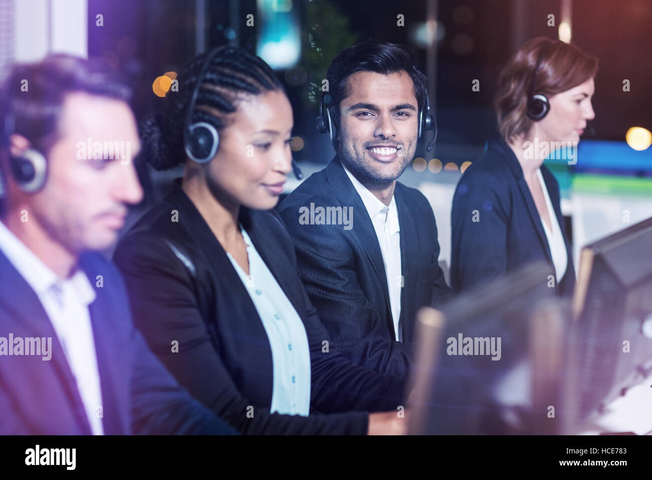 Colleagues with headsets using computer at office Stock Photo Alamy