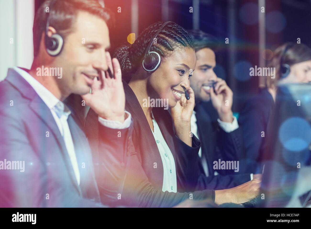 Colleagues with headsets using computer at office Stock Photo Alamy