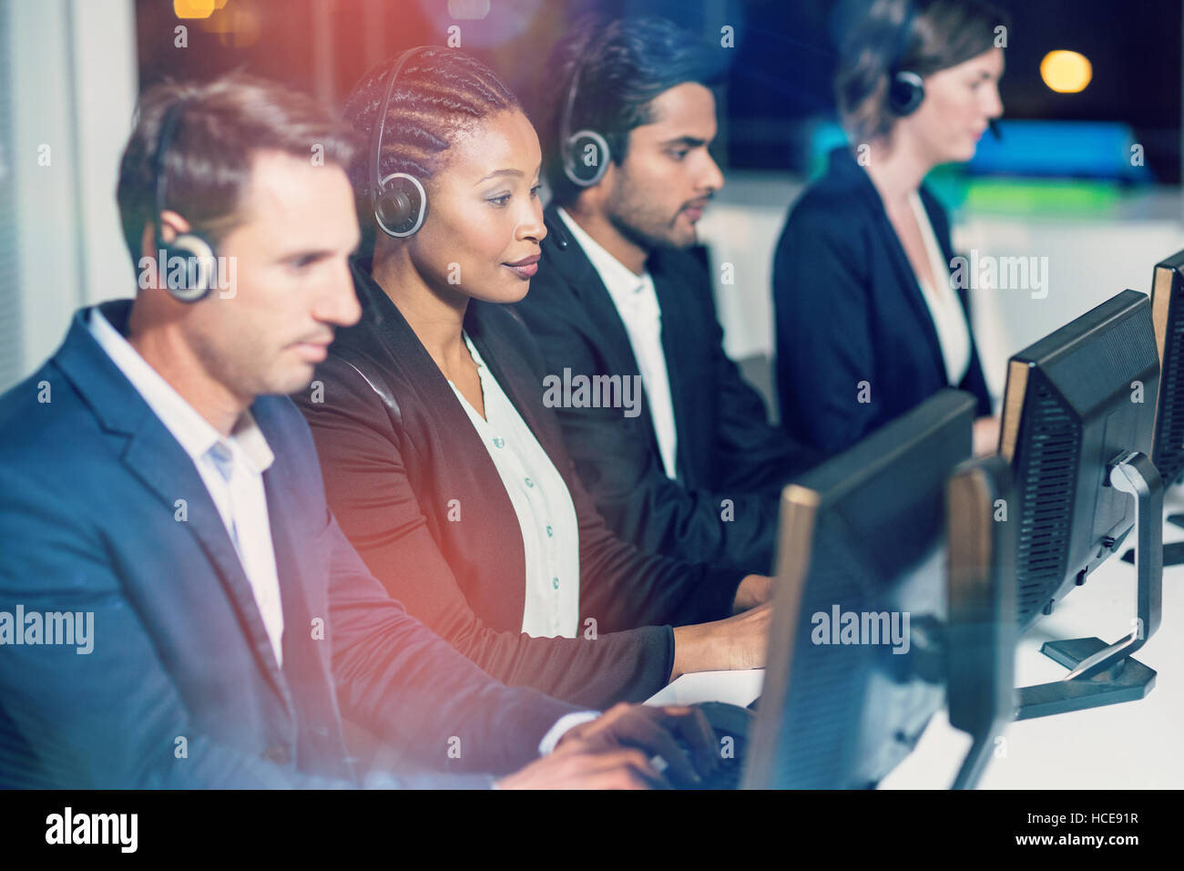 Colleagues with headsets using computer at office Stock Photo Alamy