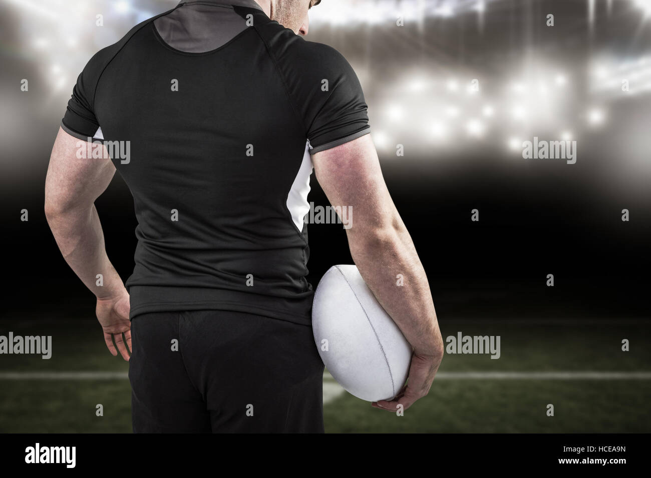 Composite image of tough rugby player holding ball Stock Photo