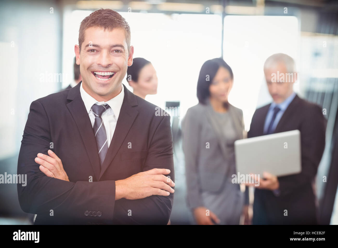 Portrait of businessman standing with arms crossed Stock Photo - Alamy