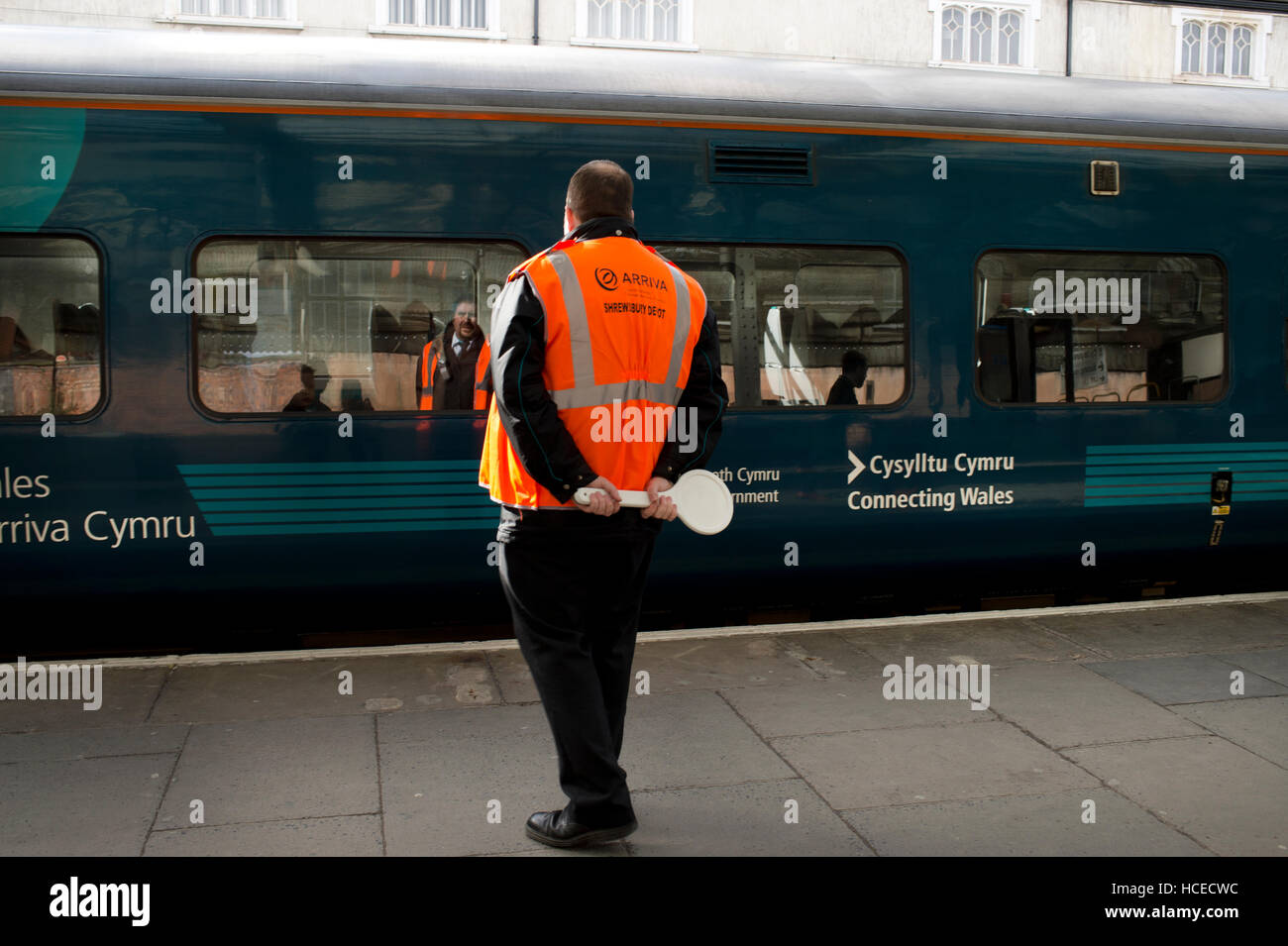 Shropshire. Guard about to wave off Arriva Wales train, Shrewsbury station Stock Photo