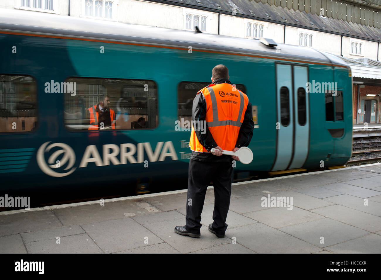 Guard about to wave off Arriva Wales train, Shrewsbury station Stock