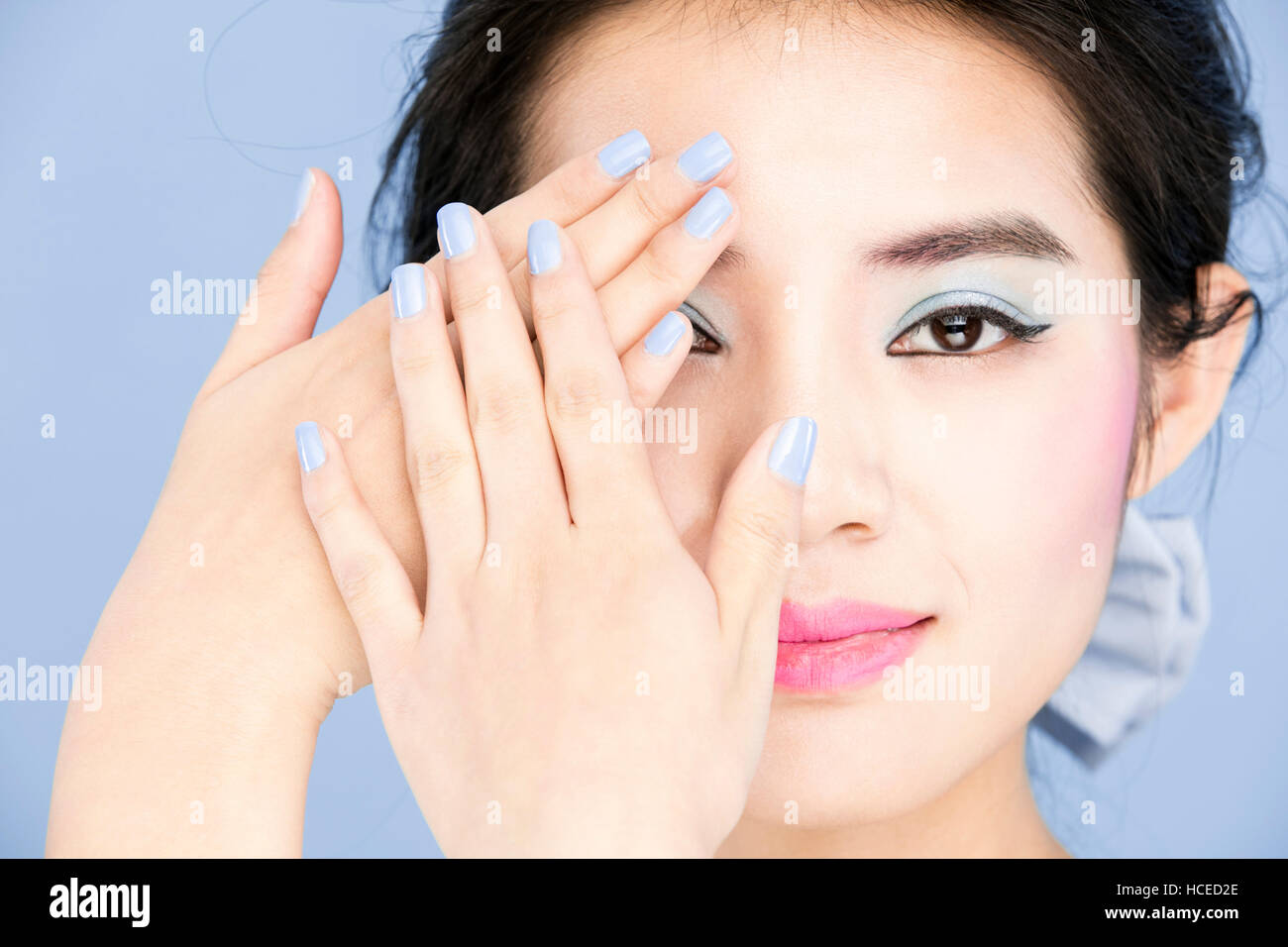 Portrait of young woman with pink lips and serenity color nails Stock Photo