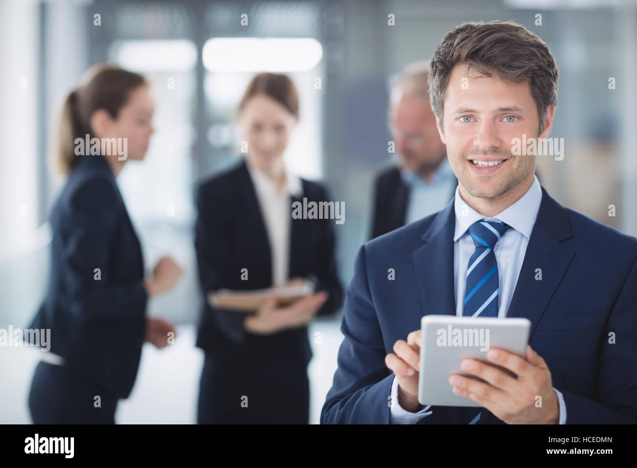 Cheerful businessman tablet standing hi-res stock photography and ...