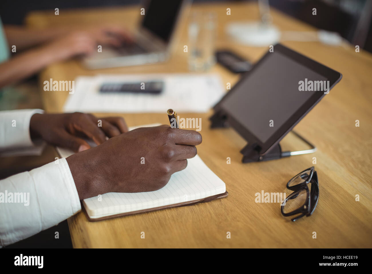 Businessman writing in a diary at desk in office Stock Photo