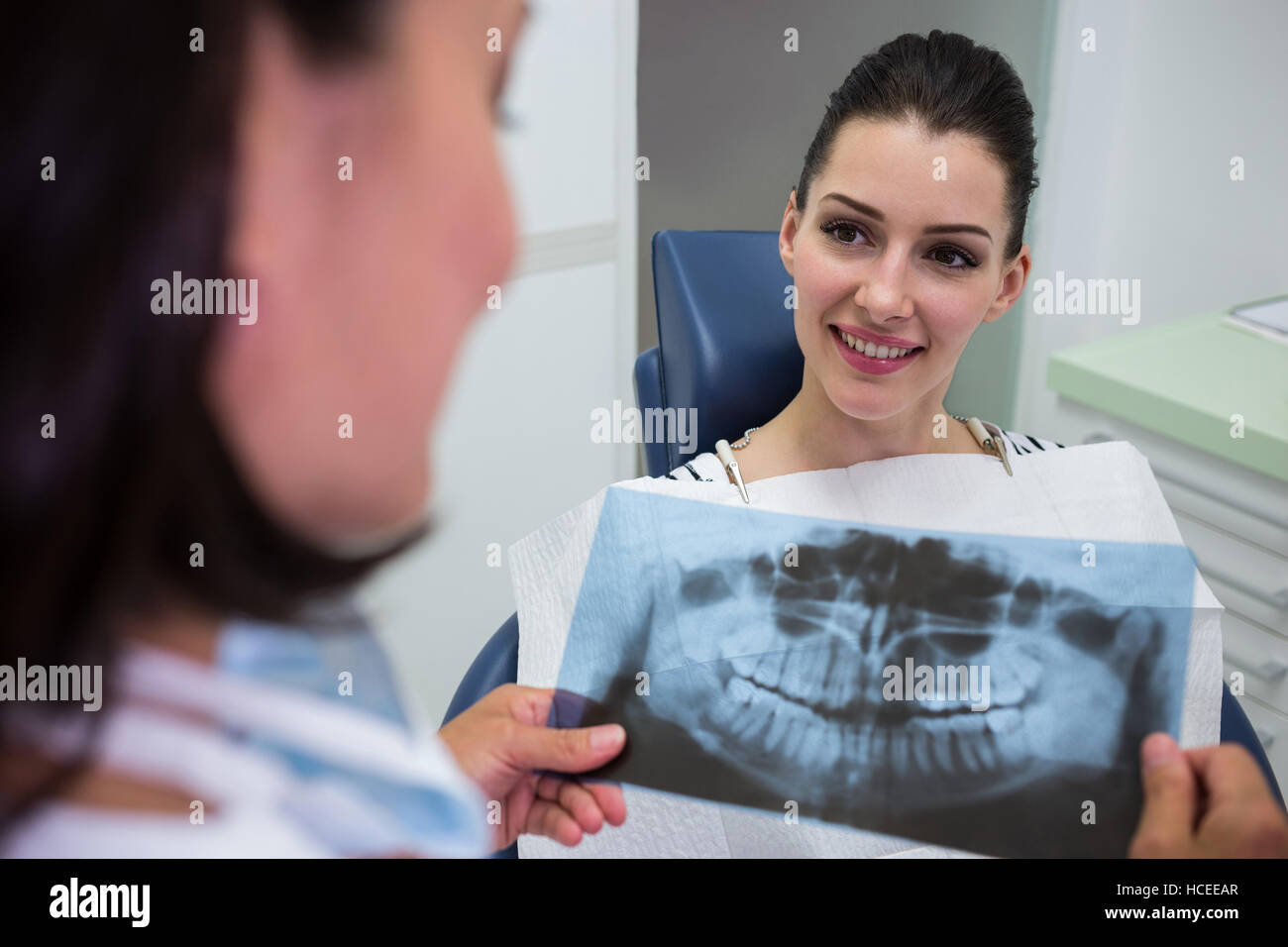 Dentist discussing with patient over x-ray report Stock Photo