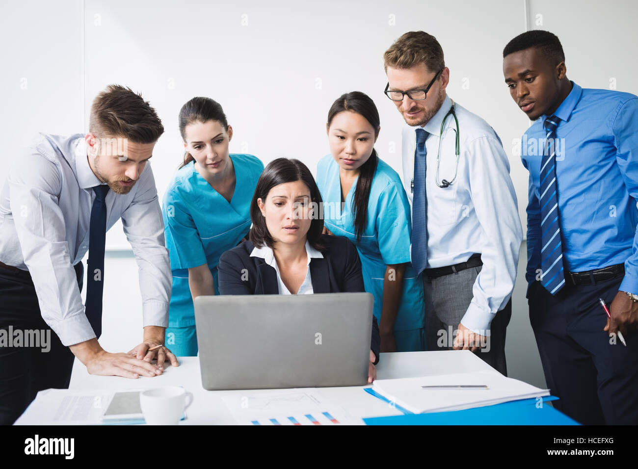 Team of doctor discussing over laptop in meeting Stock Photo