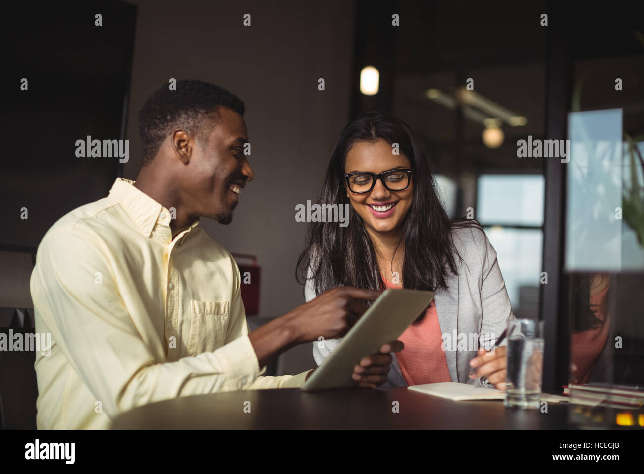 Businessman and a colleague discussing over digital tablet Stock Photo