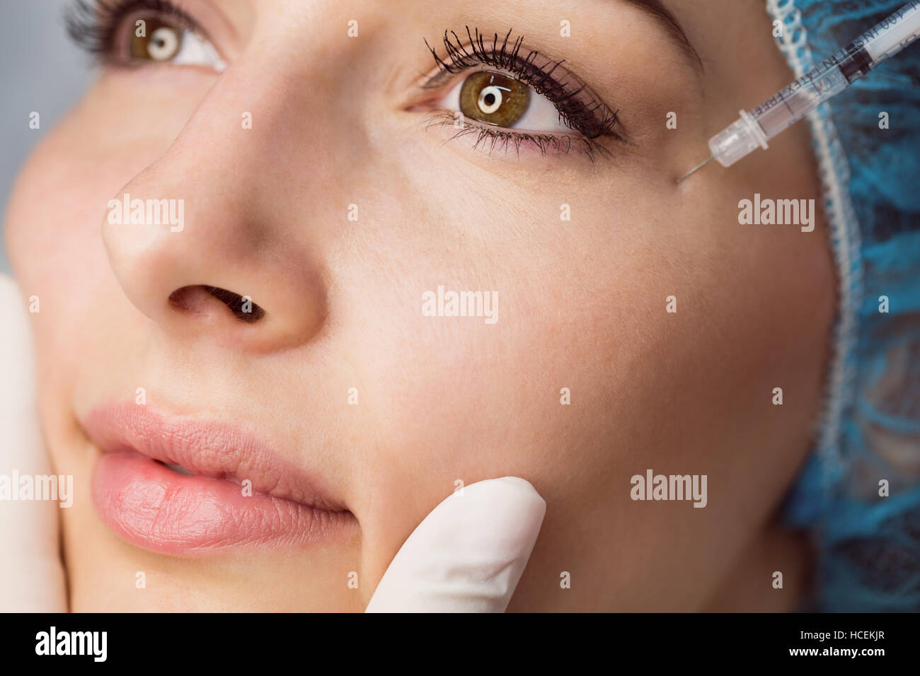 Young woman receiving botox injection on her face Stock Photo
