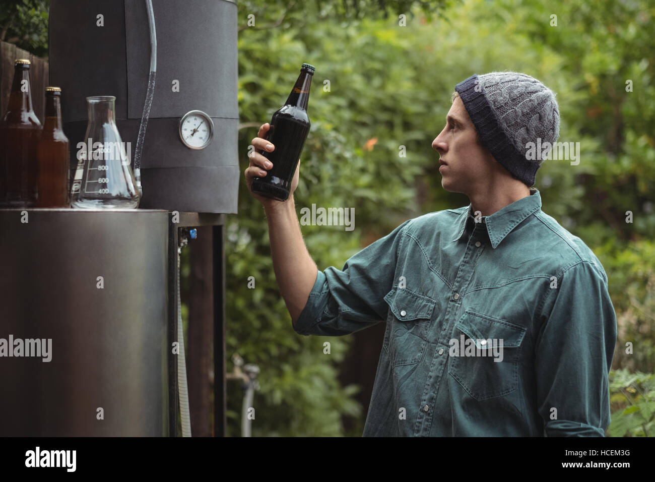 Man holding beer bottle while making beer Stock Photo
