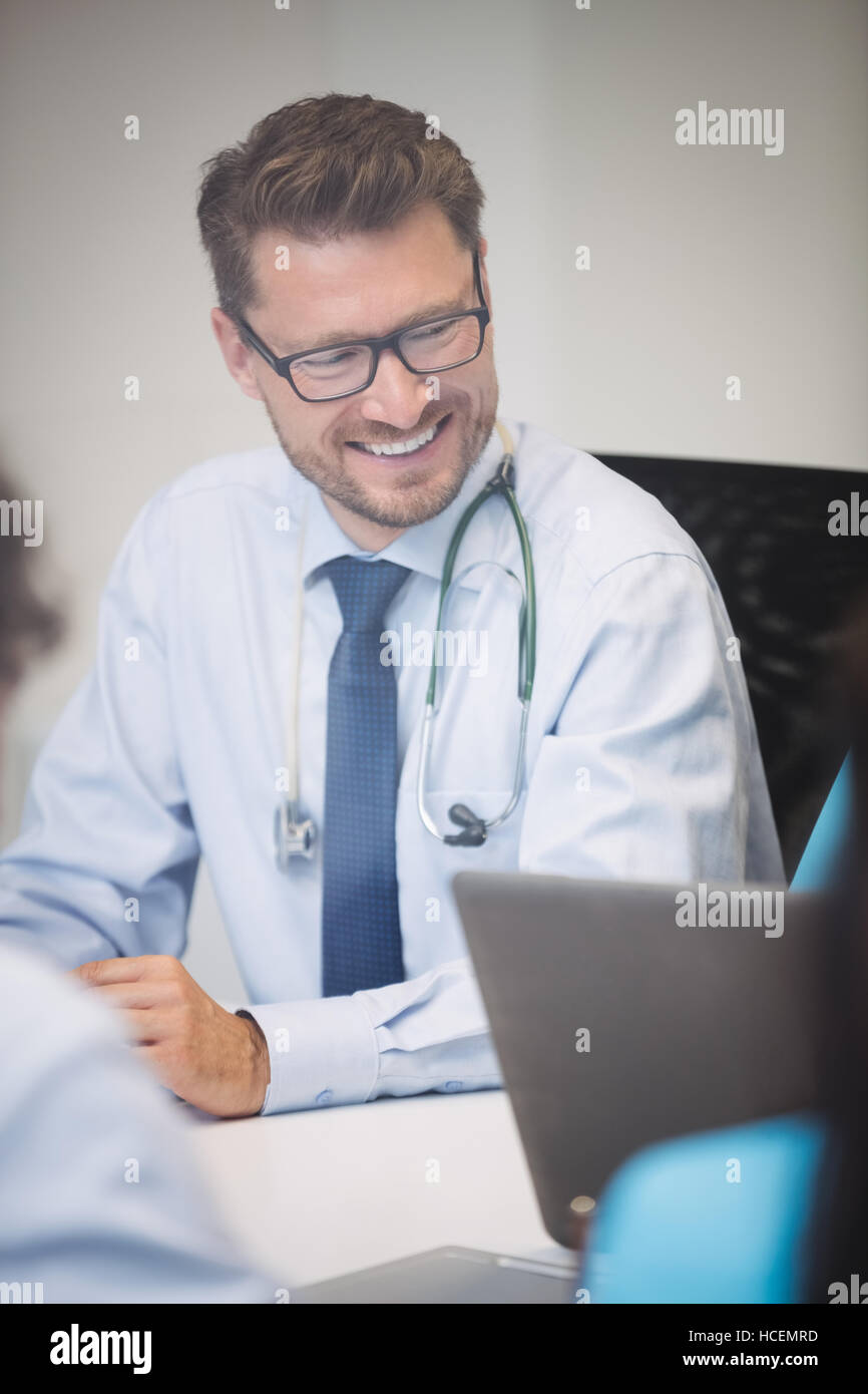 Mature smiling doctor sitting hi-res stock photography and images - Alamy