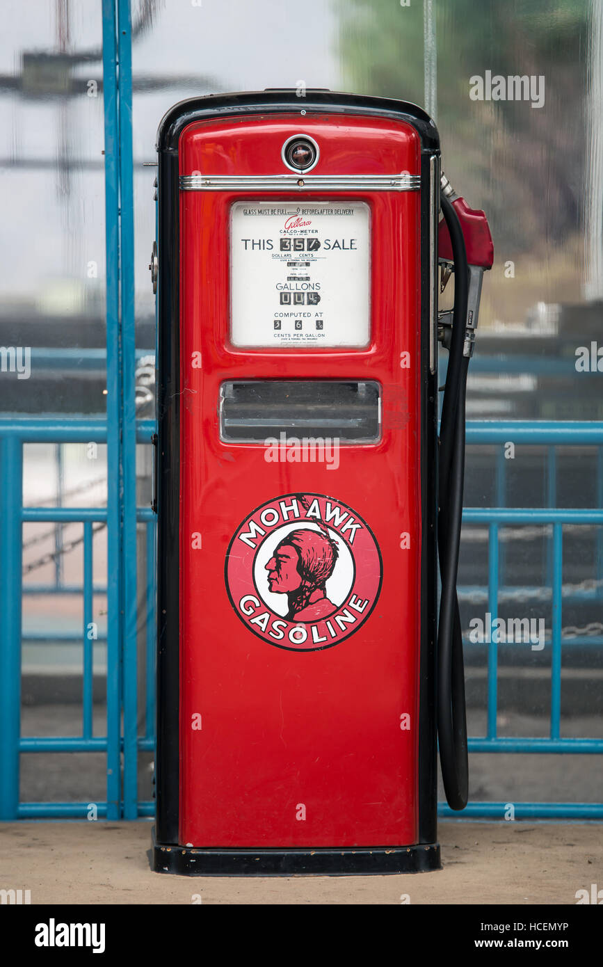 Ancient gas pump painted in black and Bright red in the setting of an old gas station Stock Photo