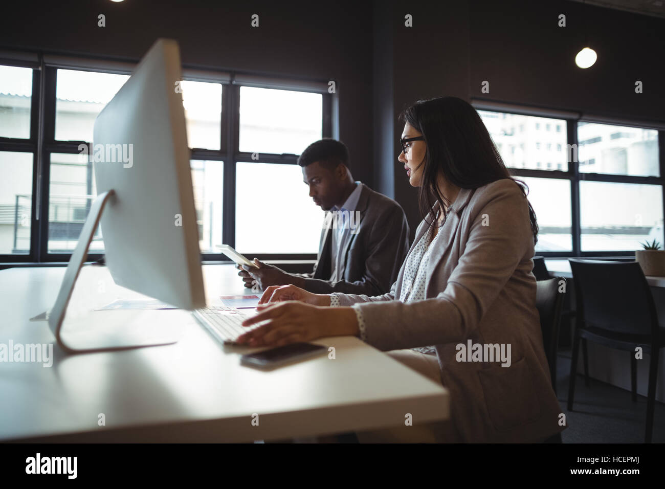 Businessman and a colleague working at their desk Stock Photo