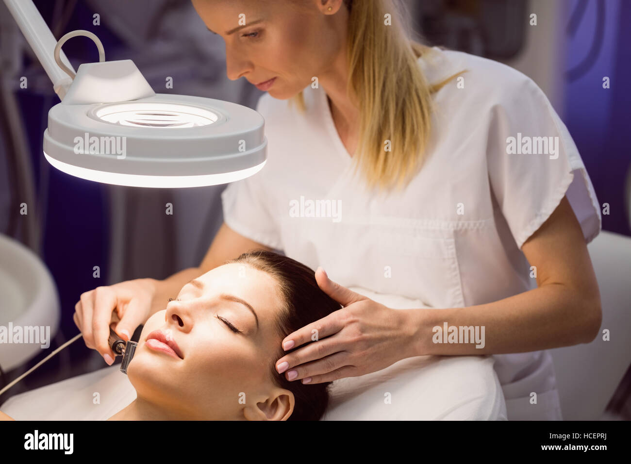 Dermatologist performing laser hair removal on patient Stock Photo Alamy