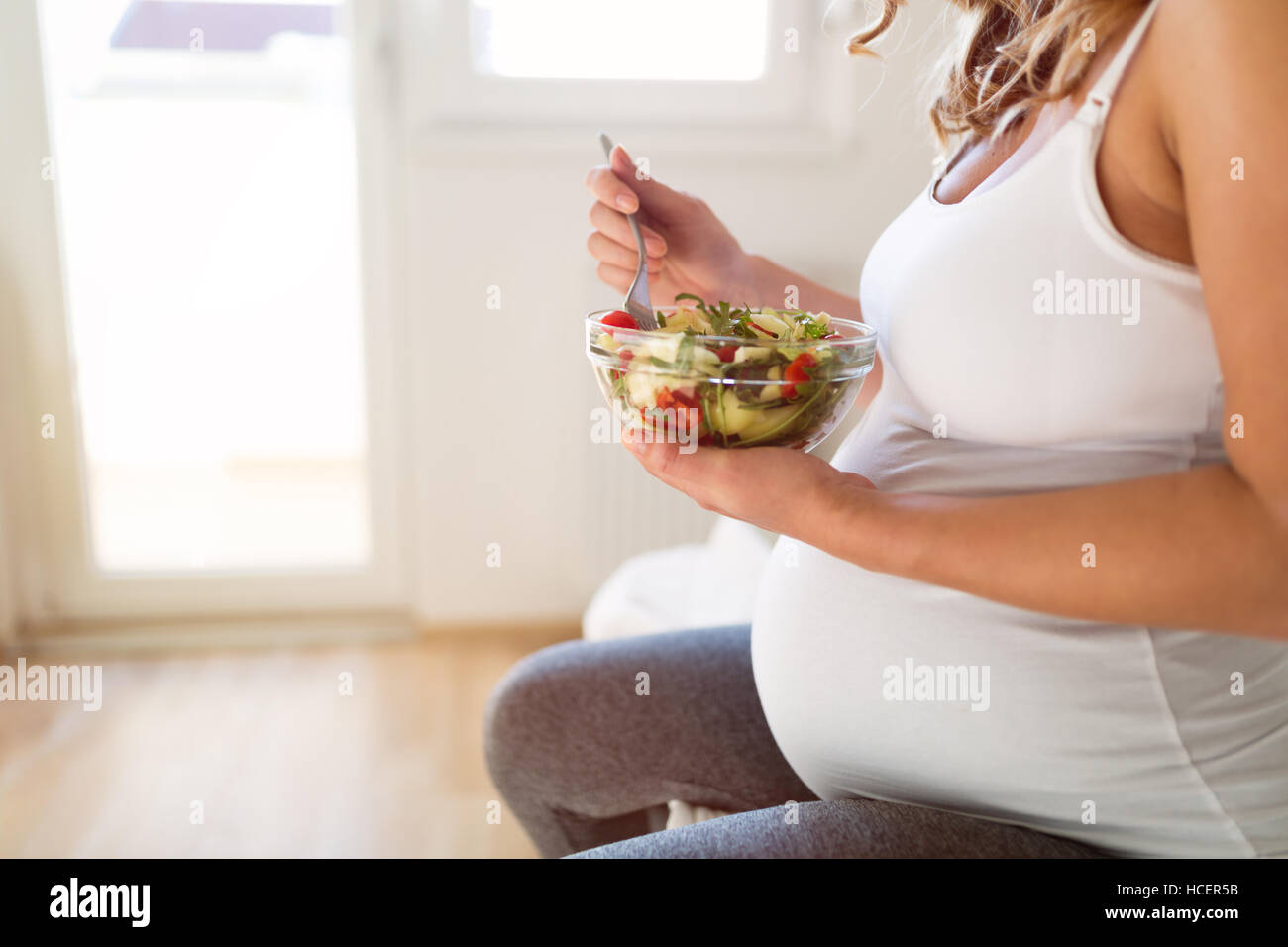 Pregnant woman eating  fresh healthy salad Stock Photo