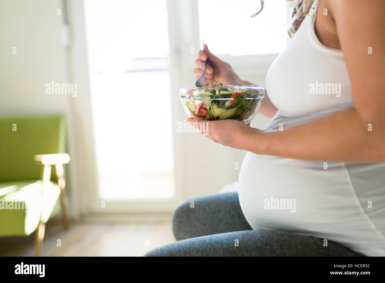 Pregnant woman on  healthy diet holding salad Stock Photo